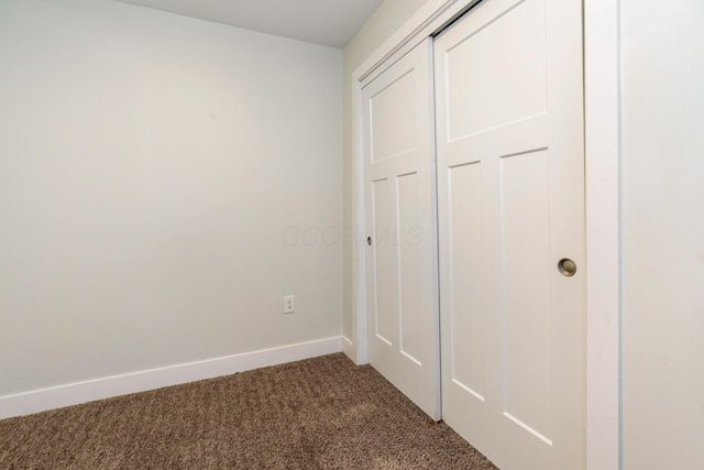 unfurnished bedroom with carpet floors, a closet, and baseboards