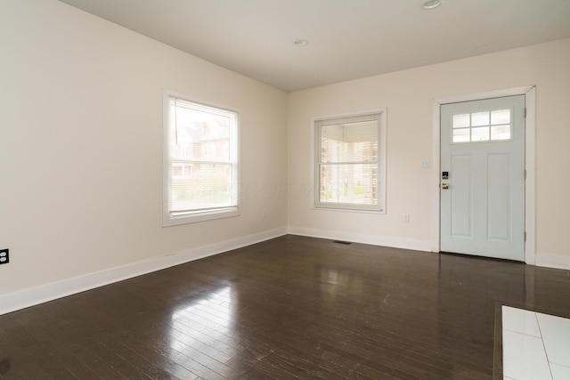 foyer entrance with wood-type flooring, plenty of natural light, visible vents, and baseboards