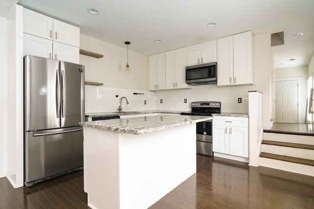 kitchen featuring decorative backsplash, white cabinetry, dark wood-type flooring, and appliances with stainless steel finishes