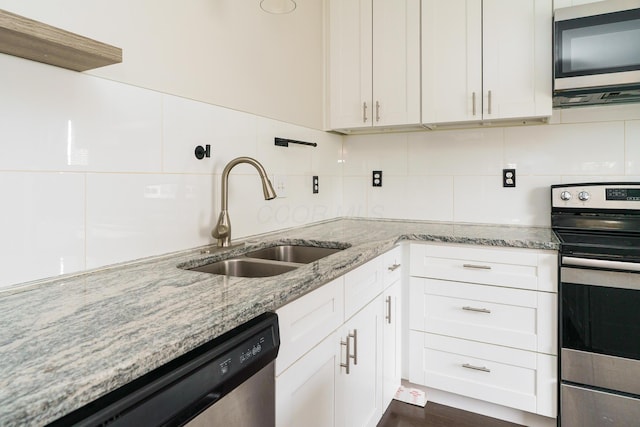 kitchen with backsplash, appliances with stainless steel finishes, light stone counters, and a sink