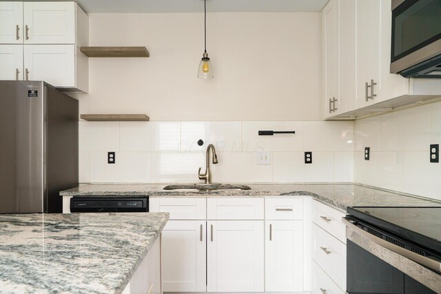 kitchen with stainless steel appliances, open shelves, backsplash, a sink, and white cabinetry