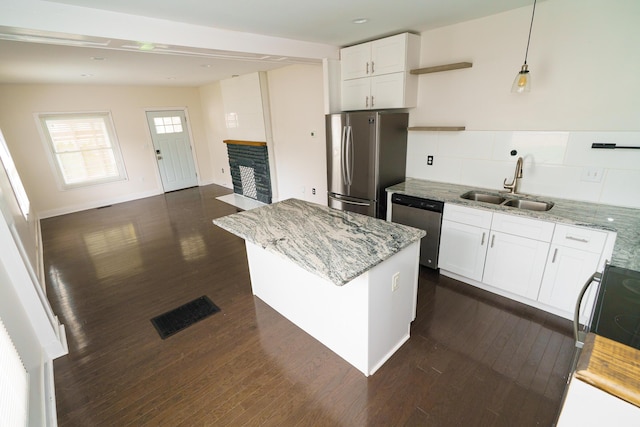 kitchen featuring dark wood-style floors, appliances with stainless steel finishes, a sink, and visible vents