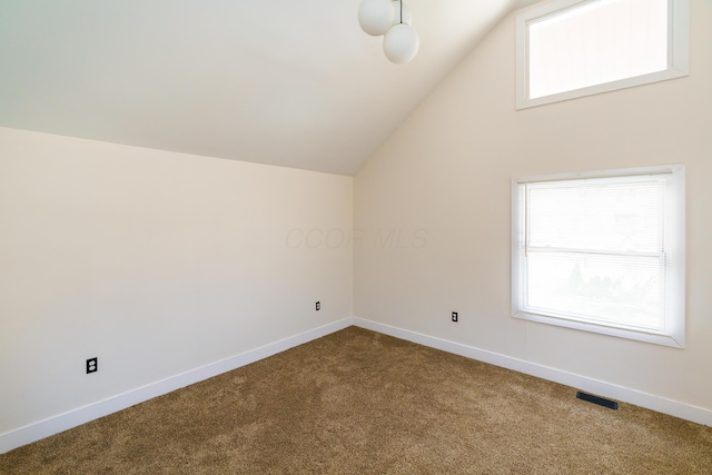 additional living space with dark carpet, lofted ceiling, and baseboards