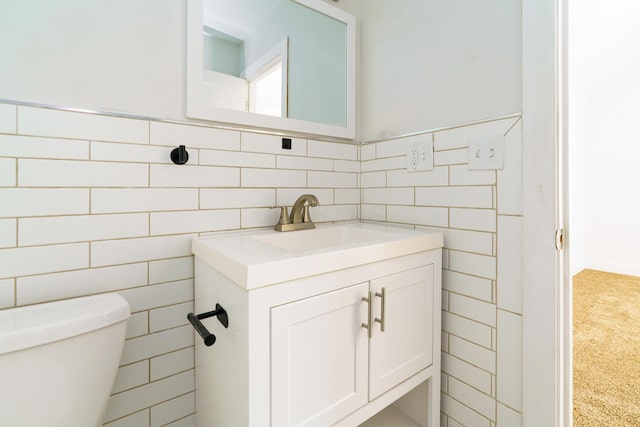 bathroom with tile walls, toilet, and vanity