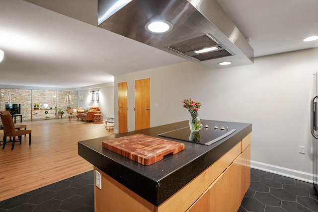 kitchen with black electric stovetop, a center island, dark tile patterned floors, and open floor plan