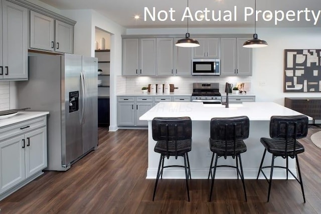 6326 Anguria Dr Lot 244, Hilliard, OH 43026 - kitchen featuring stainless steel appliances, gray cabinetry, dark wood-style flooring, and a breakfast bar