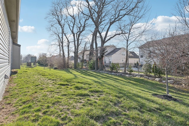 view of yard featuring fence and a residential view