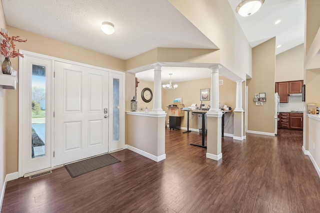 entrance foyer with visible vents, dark wood-style floors, baseboards, and ornate columns