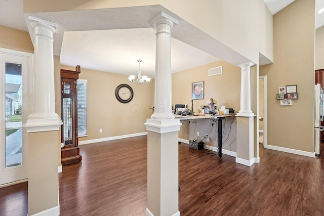 entryway with dark wood-type flooring, baseboards, visible vents, and decorative columns