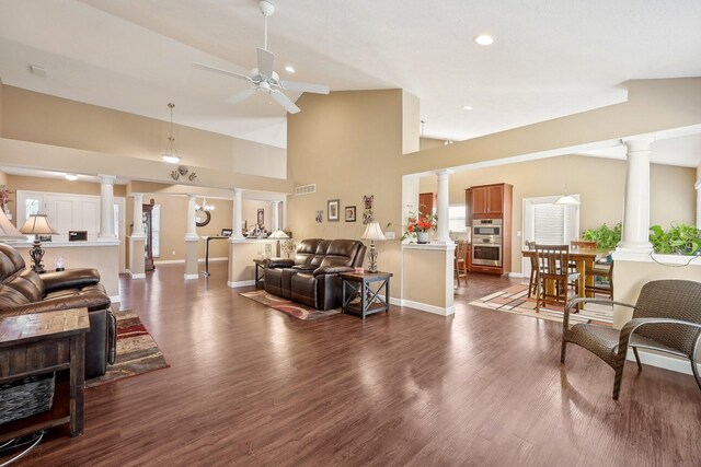 living area with visible vents, dark wood-type flooring, ceiling fan, and ornate columns