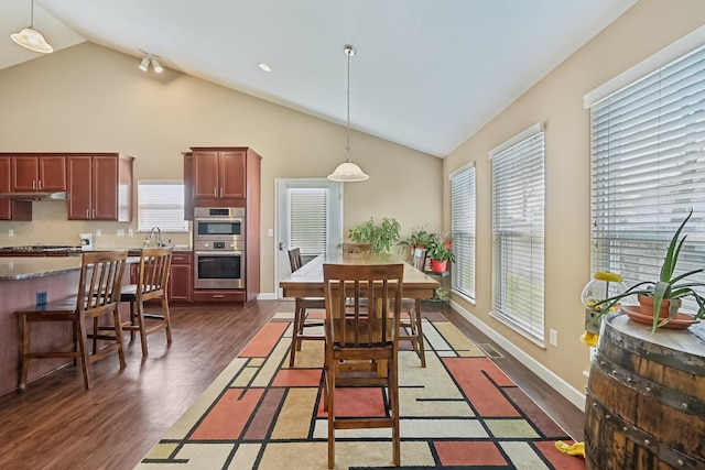 dining area featuring high vaulted ceiling, dark wood-style floors, baseboards, and visible vents