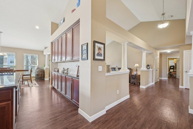 hall featuring baseboards, high vaulted ceiling, decorative columns, and dark wood finished floors