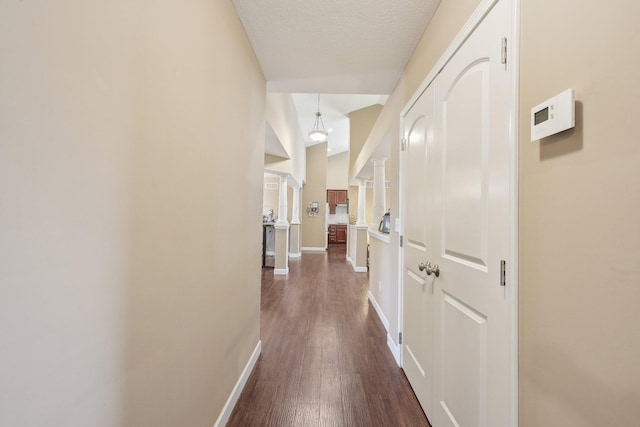 hall featuring baseboards, a textured ceiling, and dark wood finished floors