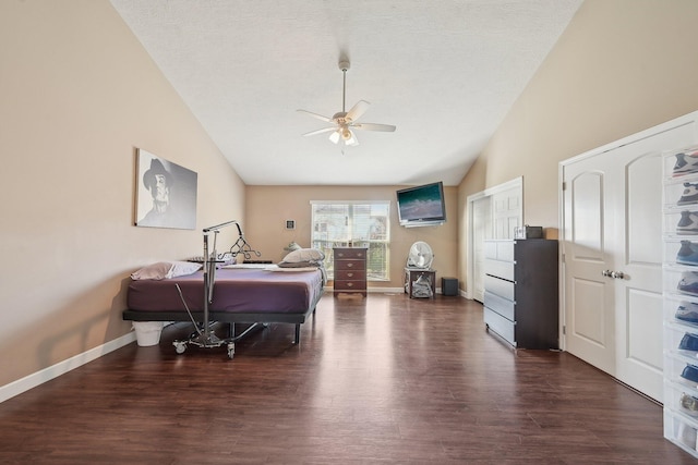 bedroom featuring a textured ceiling, baseboards, a ceiling fan, dark wood-type flooring, and lofted ceiling
