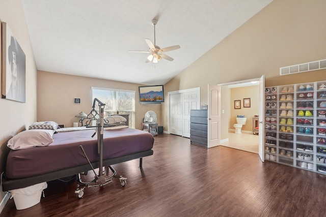 bedroom featuring a closet, visible vents, wood finished floors, a ceiling fan, and ensuite bath