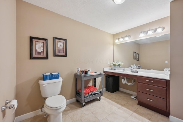 bathroom featuring baseboards, toilet, tile patterned floors, and vanity