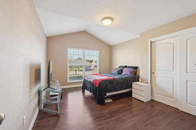 bedroom featuring baseboards, a textured ceiling, lofted ceiling, and dark wood finished floors