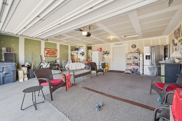 garage featuring a garage door opener and stainless steel refrigerator with ice dispenser