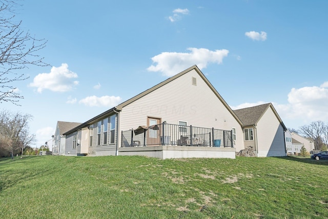 rear view of property featuring a deck and a yard