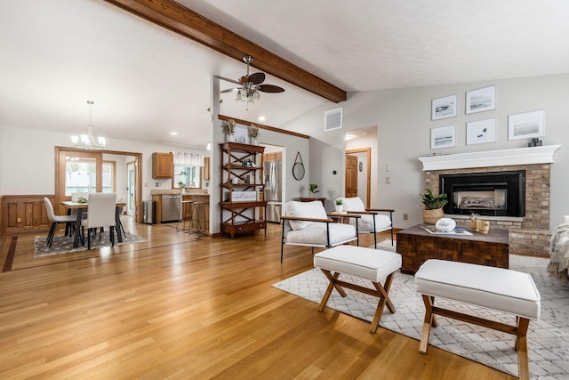 living room featuring lofted ceiling with beams, light wood-type flooring, a fireplace, visible vents, and recessed lighting