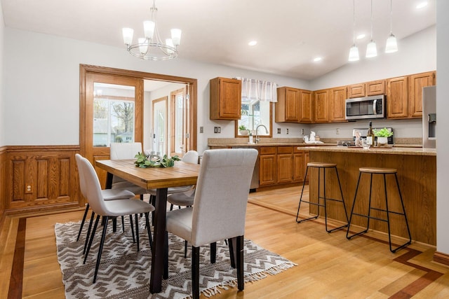 dining space featuring recessed lighting, a notable chandelier, lofted ceiling, and light wood-style flooring