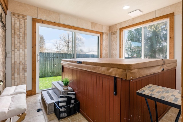 sunroom featuring a hot tub and plenty of natural light