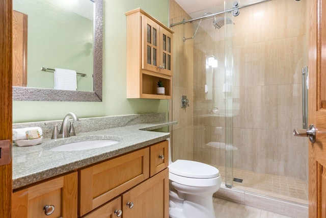 full bathroom with toilet, vanity, and a stall shower