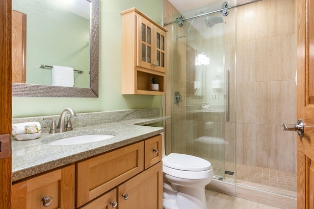 bathroom with vanity, a shower stall, and toilet