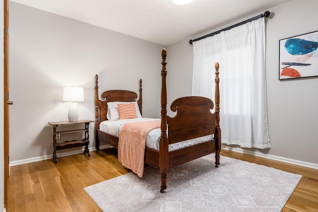 bedroom featuring baseboards and wood finished floors
