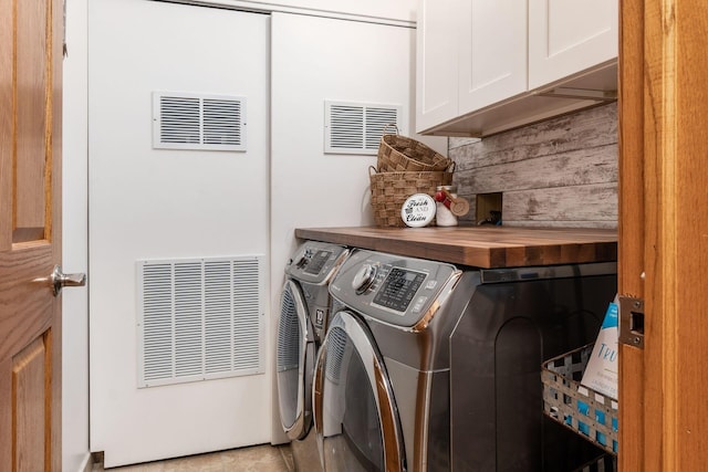 laundry area with visible vents, independent washer and dryer, and cabinet space