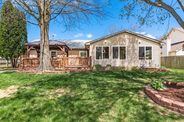 rear view of house featuring a gazebo, a yard, fence, and a deck