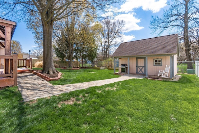 view of yard featuring fence, an outdoor structure, and a deck