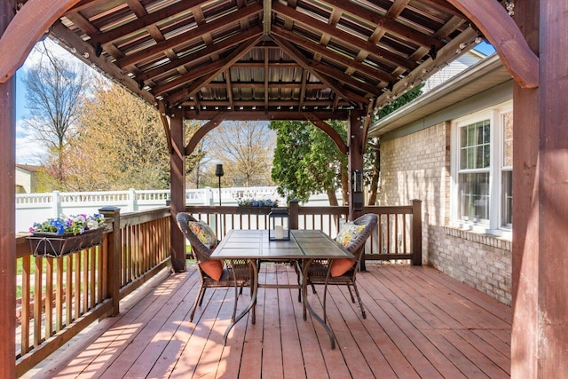 deck featuring outdoor dining area, a gazebo, and fence