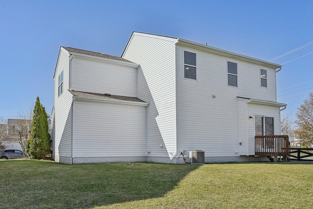 rear view of house with a deck, central AC, and a yard
