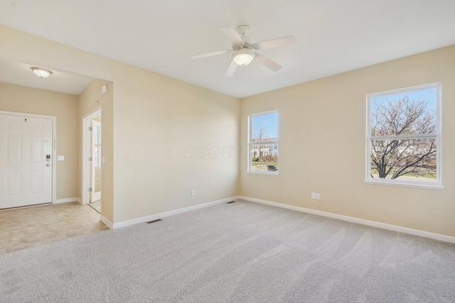 unfurnished room featuring light carpet, baseboards, visible vents, and ceiling fan
