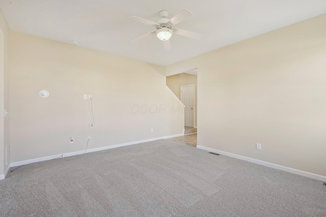 empty room with visible vents, baseboards, light colored carpet, and ceiling fan