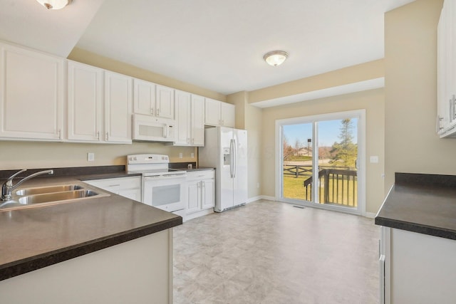 kitchen with white cabinetry, white appliances, baseboards, a sink, and dark countertops