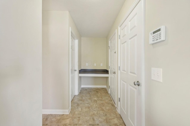 hall featuring baseboards