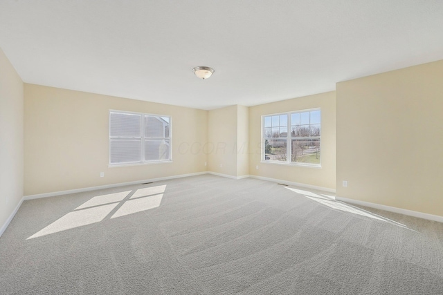 carpeted spare room featuring baseboards