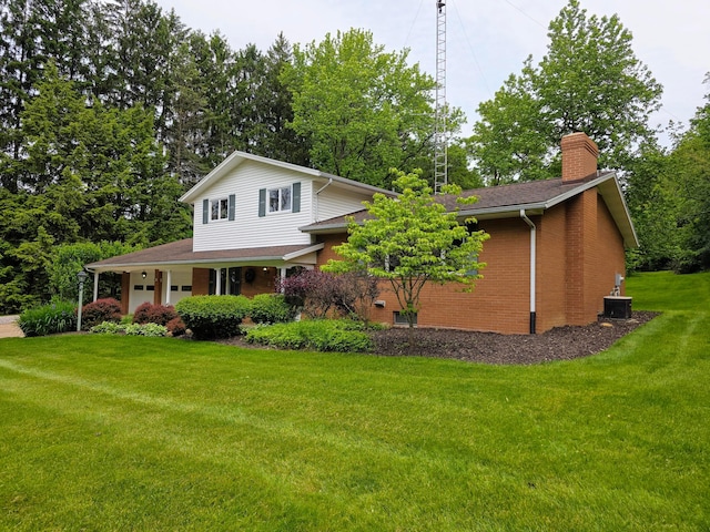 5344 Ridge Ave SE, Canton, OH 44707 - view of front of home with a chimney, a front lawn, brick siding, central air condition unit, and an attached garage