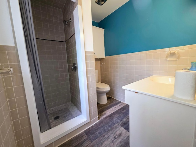 5344 Ridge Ave SE, Canton, OH 44707 - full bathroom with tile walls, wood finished floors, toilet, a stall shower, and a wainscoted wall