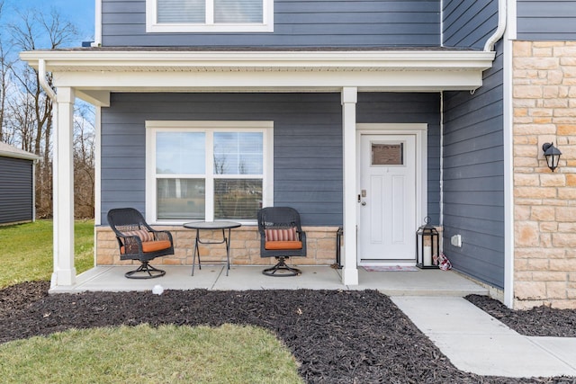 property entrance featuring a porch and stone siding