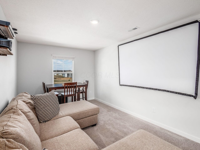 home theater with baseboards, visible vents, carpet, and a textured ceiling