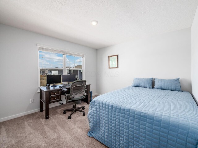 carpeted bedroom with baseboards and a textured ceiling