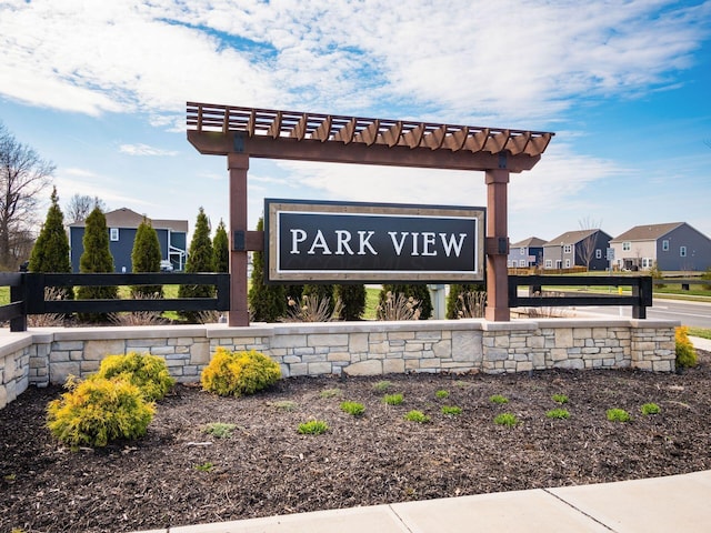 community / neighborhood sign with fence and a residential view