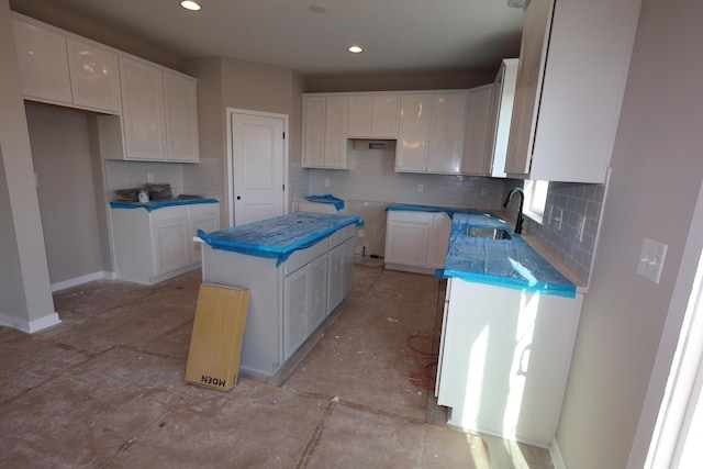 kitchen featuring a sink, white cabinets, backsplash, baseboards, and recessed lighting