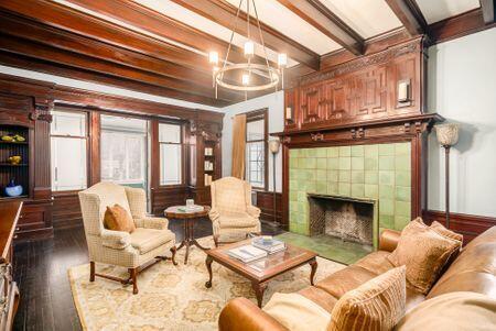 1349 E Broad St, Columbus, OH 43205 - living area with beamed ceiling, a tiled fireplace, wood finished floors, and a chandelier