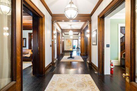 1349 E Broad St, Columbus, OH 43205 - hallway with ornamental molding, baseboards, a chandelier, and wood finished floors