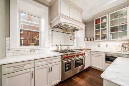 1349 E Broad St, Columbus, OH 43205 - kitchen with dark wood finished floors, custom range hood, decorative backsplash, and ornamental molding