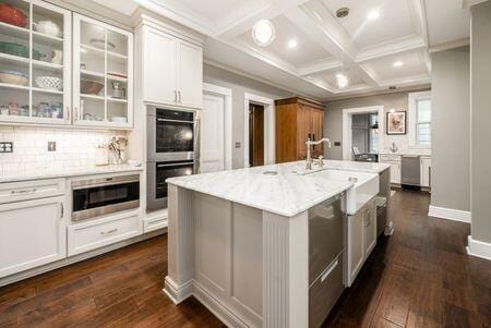 1349 E Broad St, Columbus, OH 43205 - kitchen featuring coffered ceiling, stainless steel appliances, dark wood finished floors, beamed ceiling, and glass insert cabinets